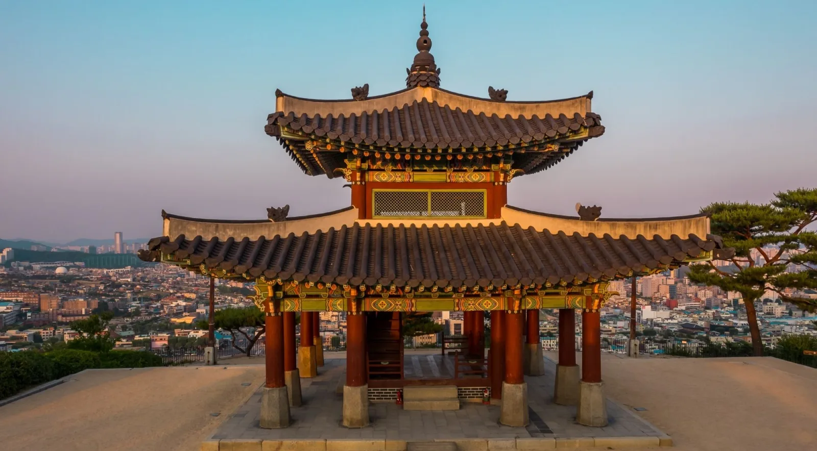 Seojangdae command post pavilion on Paldalsan hill above the Suwon skyline at dusk