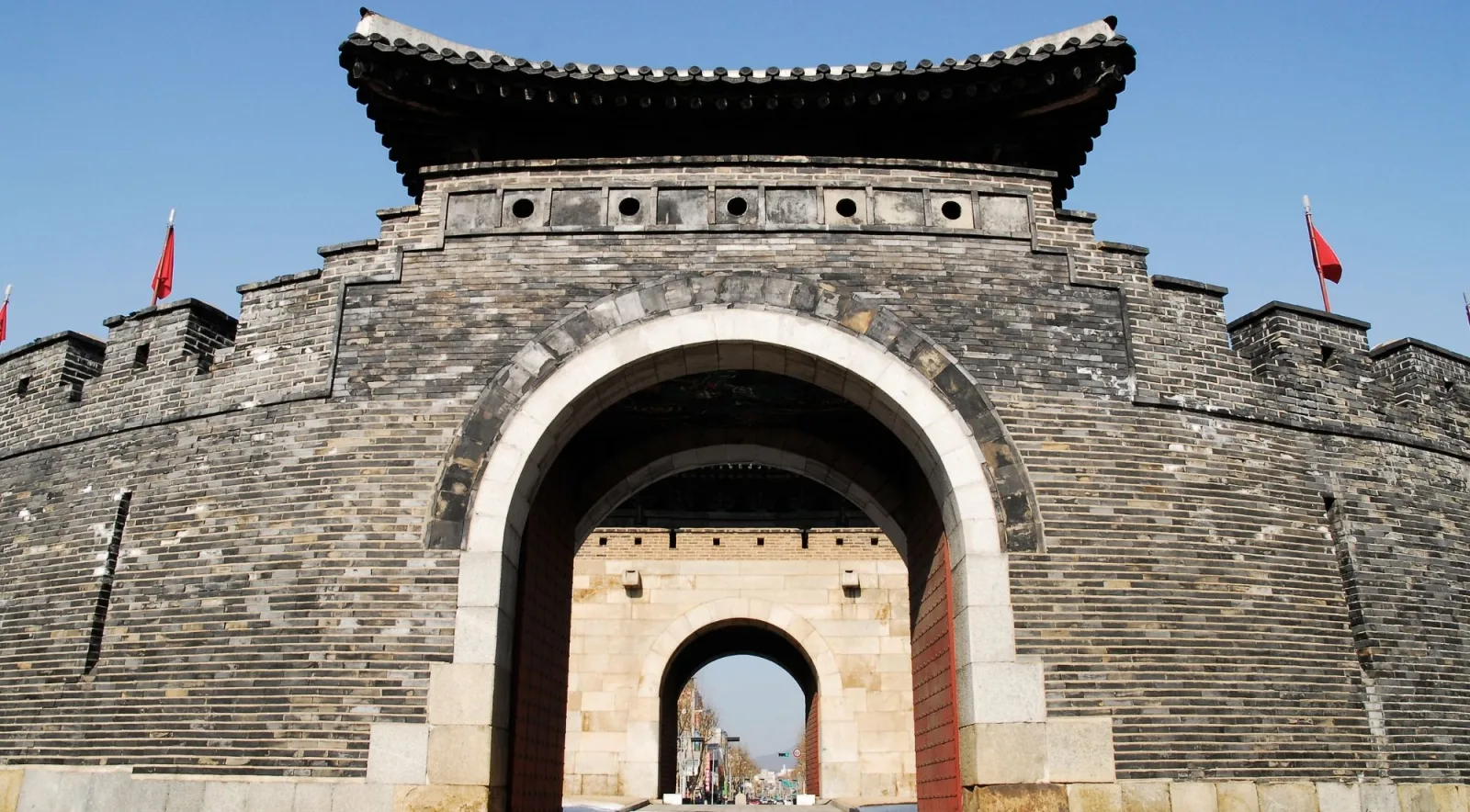 Looking up through the arched stone gateway of a Hwaseong Fortress gate