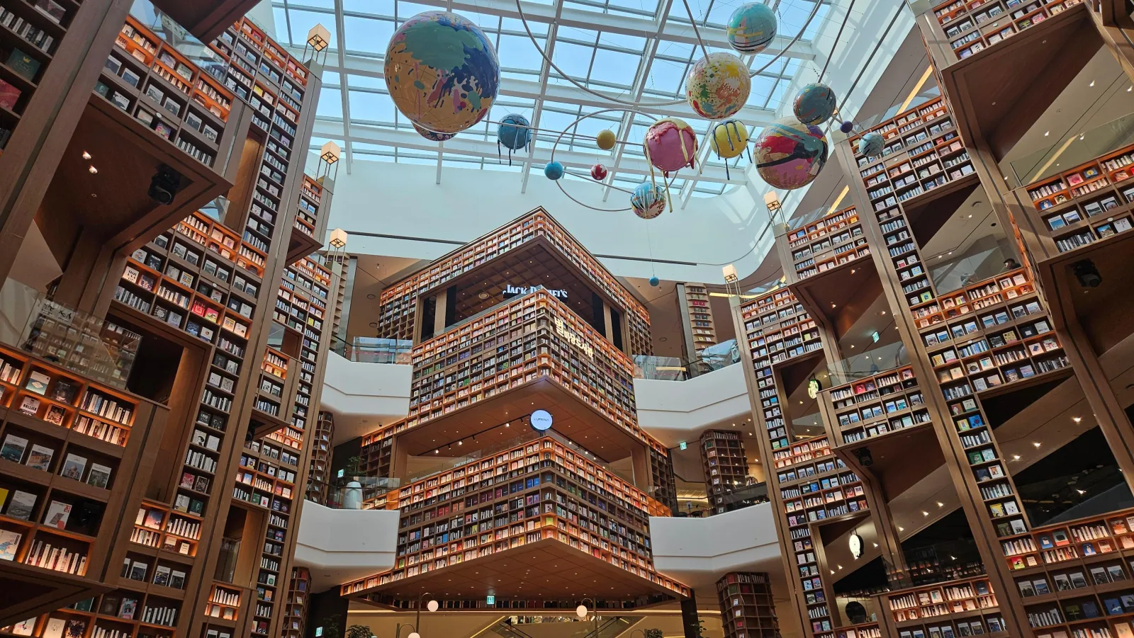 Hot-air balloons hanging above the bookshelf atrium of Starfield Suwon library