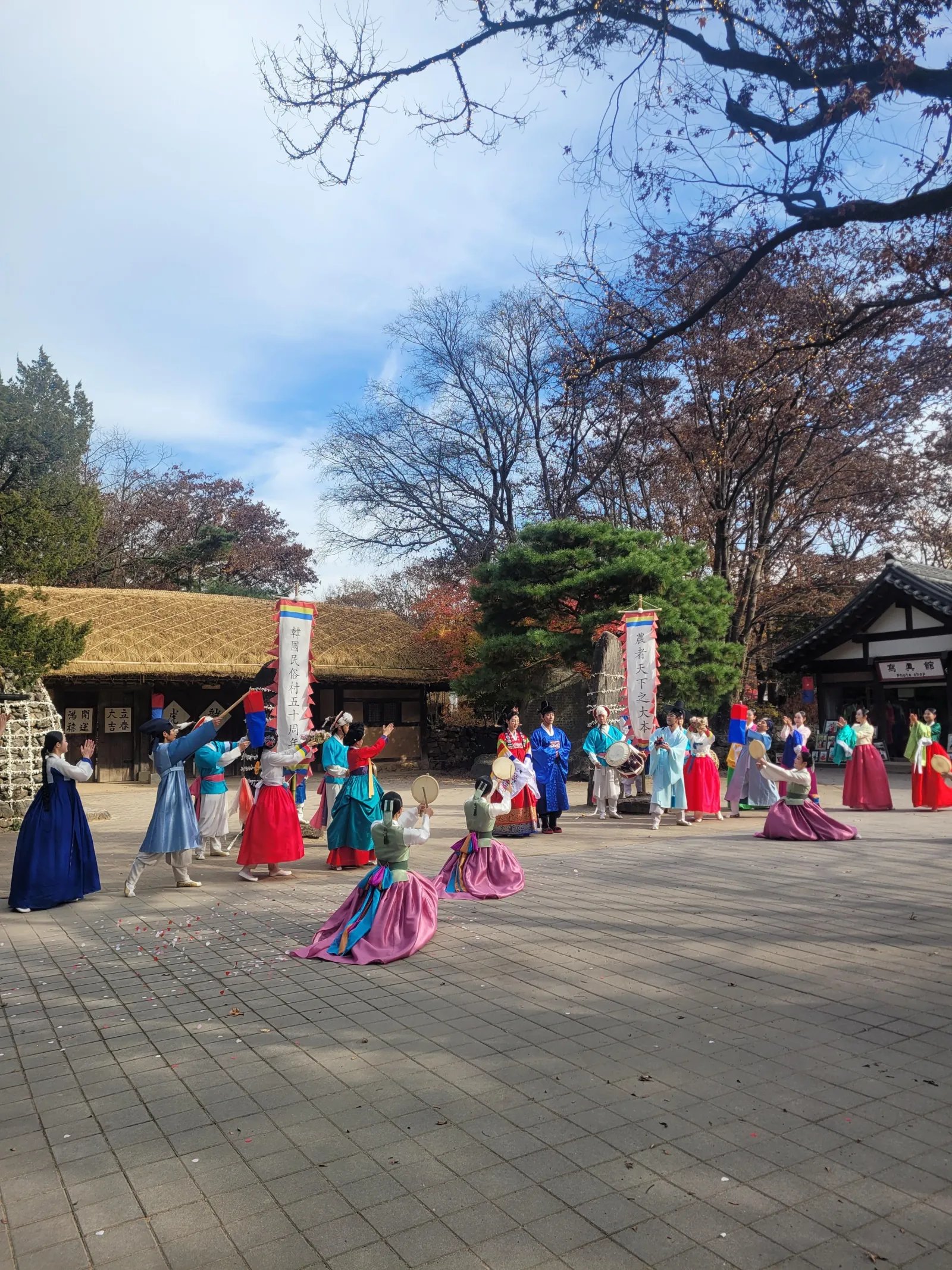Visitors in hanbok crossing the courtyard at the Korean Folk Village