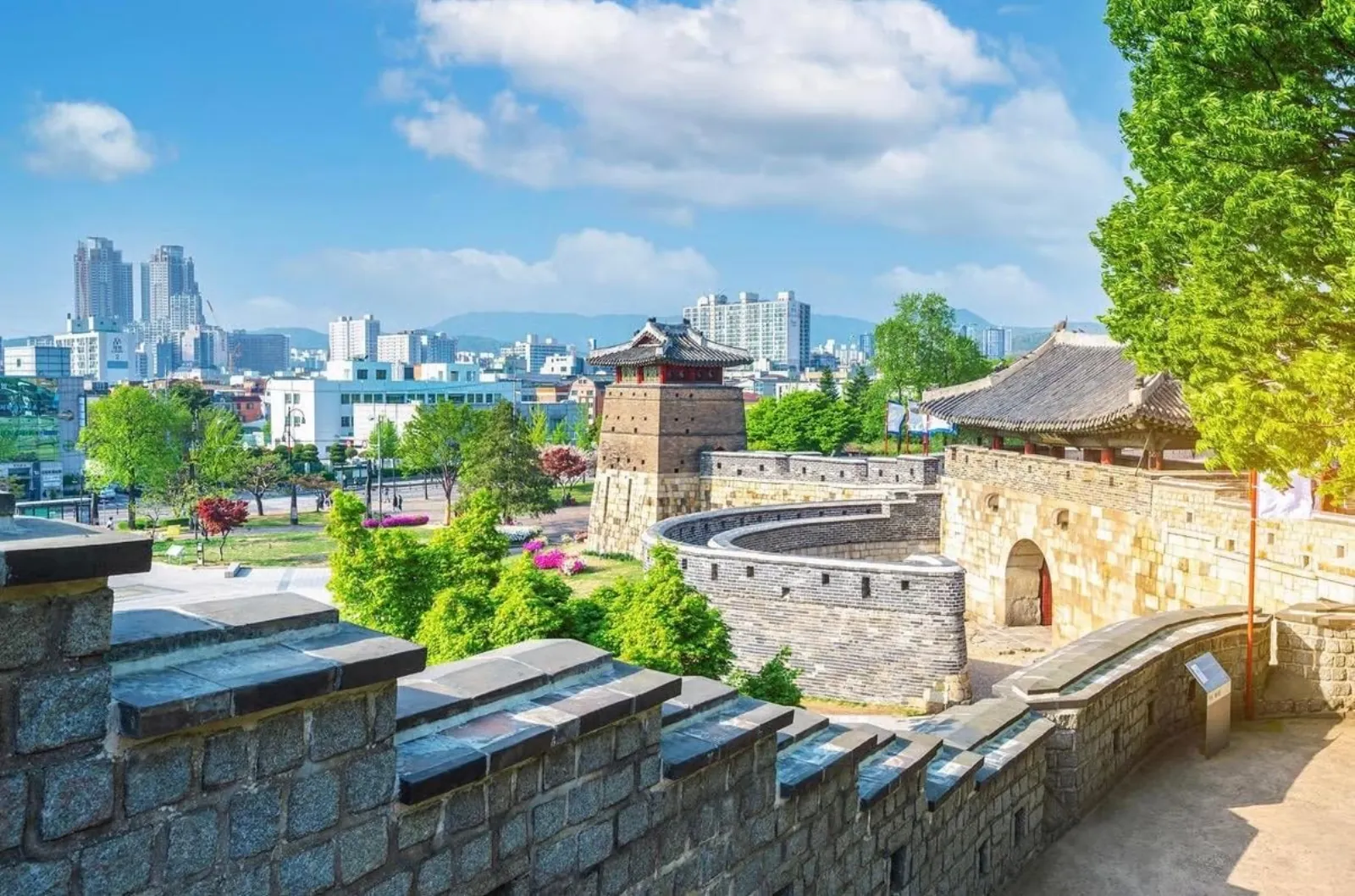 Hwaseong Fortress wall and watchtower with the modern Suwon skyline behind