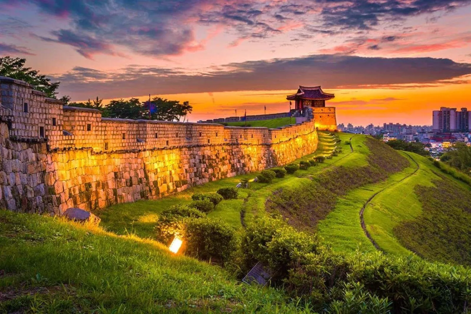 Golden-hour light on the Hwaseong Fortress rampart and grass embankment
