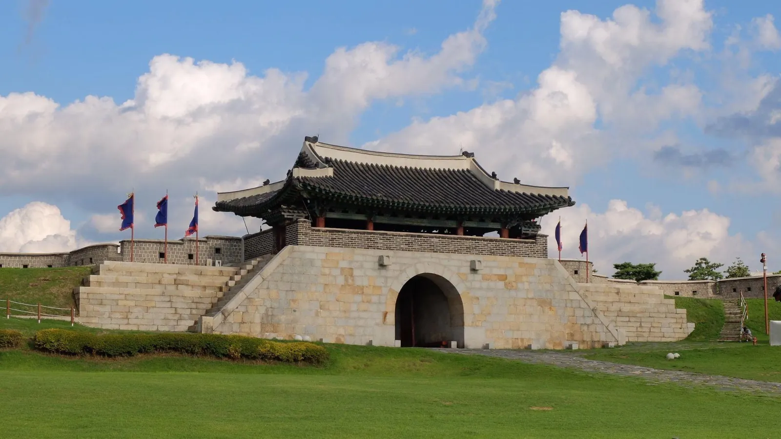 The stone Changnyongmun east gate of Hwaseong Fortress with flags flying