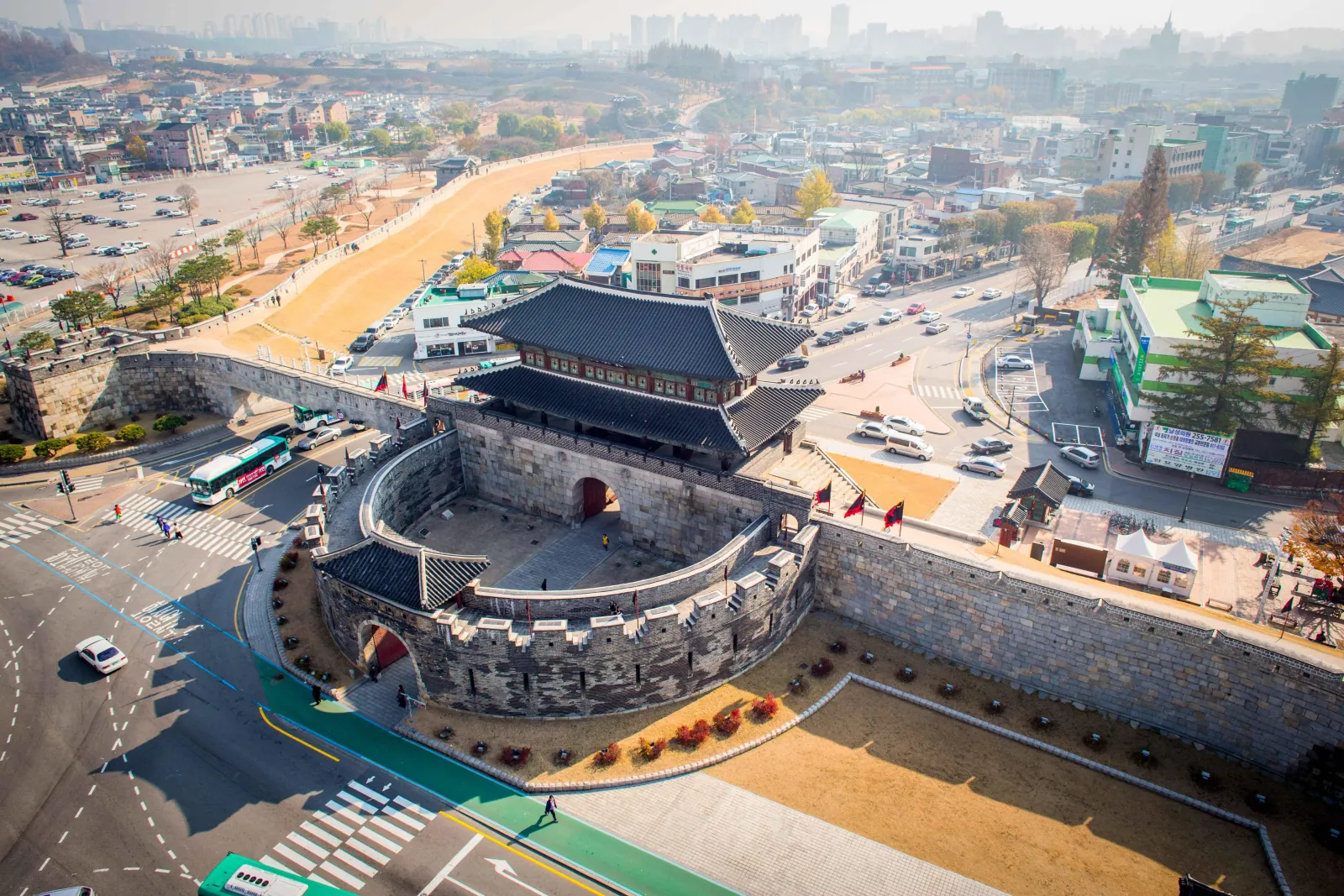 Aerial view of the round Hwaseomun gate and its walls in the middle of Suwon